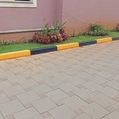 A newly laid patch of grass with a freshly painted black and yellow curb, showing progress on a development project at Sobha Carnation.