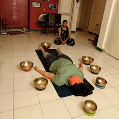 A participant experiences a full moon sound meditation, surrounded by Tibetan singing bowls. The heightened energy of the full moon is believed to enhance our receptivity to the healing vibrations, fostering a deeper connection.
