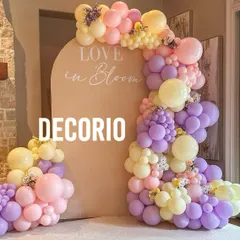 A beautiful 'Love in Bloom' themed setup with a pastel balloon garland in shades of pink, purple, and yellow. The soft colors and floral accents create a romantic and whimsical ambiance.