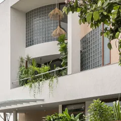 Here, the home's facade becomes a living garden. We integrated deep planters into the balconies, allowing vines and tropical foliage to cascade down, softening the structure and creating a vibrant, green exterior.
