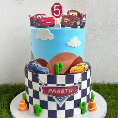 Ka-chow! This Disney Cars cake brings Lightning McQueen and Mater to the party. The design features a desert landscape and a checkered flag pattern, perfect for a high-energy birthday celebration for a young racing fan.