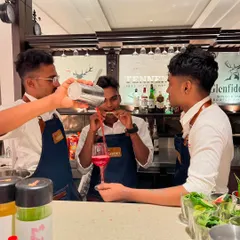 Teamwork makes the dream work. Here, three of our bartenders collaborate to create the perfect pour, showcasing their synchronized skills and fun-loving energy.