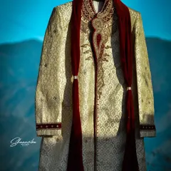 A creative shot of the groom's sherwani, hanging against a beautiful mountain backdrop. This highlights the elegance of the attire before it's even worn.