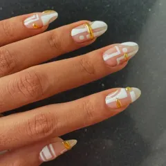 Another angle of the white and gold geometric nail art, showing how the design flows across each nail.