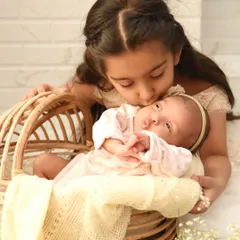 A tender moment as an older sister gives her newborn sibling a gentle kiss on the forehead. I focus on capturing these natural interactions that show the love in a growing family.