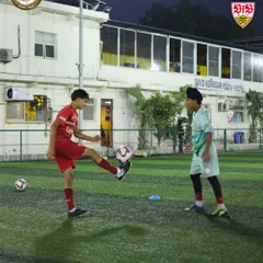 Two players practicing ball control drills in front of the David Kerrigan Youth Hostel. Our residential setup means you live and breathe football 24/7.