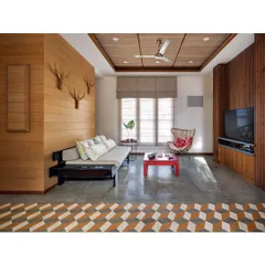 The informal living area in the Nataraj House, with its Indian daybed (divan), polished cement flooring, and banana fiber ceiling. The space is designed for comfort and warmth, reflecting an earthy, tropical aesthetic.