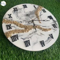A beautiful example of a marble-effect resin clock, combining black, white, and grey tones with a striking gold crystal accent. This is a classic and elegant design you can learn to make.