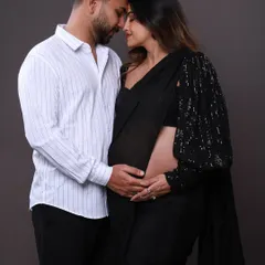An intimate close-up showing the deep connection between the couple. Dressed in a modern saree and a classic shirt, their pose is full of love and anticipation for their new arrival.
