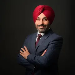 A confident, arms-crossed portrait of a business professional. The studio lighting is carefully adjusted to create a strong, defined look that conveys expertise and authority.