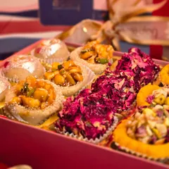 A close-up look at the artistry in my festive mithai boxes. You can see the detail of the dried rose petals, the crunch of the nuts, and the shimmer of the silver vark on each handcrafted piece.