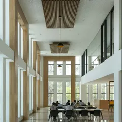 The double-height reading room at Sona University is bathed in natural northern light, creating an inspiring and comfortable environment for study. The tall windows and clean lines connect the interior with the surrounding landscape, promoting focus and well-being.