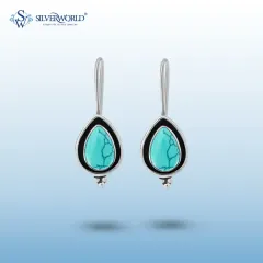 A pair of teardrop turquoise earrings, handcrafted in 92.5 sterling silver. The simple bezel setting highlights the natural beauty and veining of the turquoise stone.
