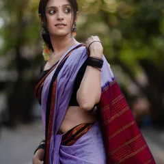 A side profile showing the beautiful fall of the Ilkal saree's pallu. The rich red and gold stripes are a hallmark of this traditional Karnataka weave.