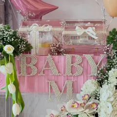 A close-up of the 'Baby M' hamper, showing the pearl-studded lettering and luxurious floral arrangement for the Malhotra baby.