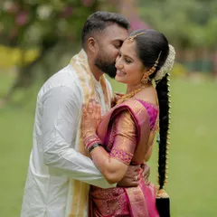 A tender embrace filled with happiness. The groom's kiss and the bride's joyful smile make this a perfect candid portrait, capturing a moment of pure love.
