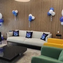 A stylish and branded lounge area for a corporate event. We provided custom logo-printed pillows for the couches and placed personalized balloon bouquets around the room to reinforce the company's brand identity during the celebration.