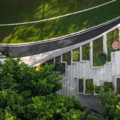 An aerial view of the landscape design for Villa KD 45, showing the interplay of curved pathways, terraced planters, and lush green lawns that complement the architecture.