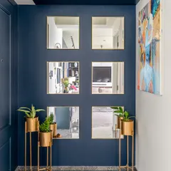 An entrance should be inviting. For the Maloo Residence, we chose a bright blue door with glass panels, paired it with a vibrant piece of art and gold-accented planters to create a sophisticated and welcoming first impression.