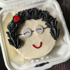 A sweet portrait cake for a grandmother's birthday. I used piped buttercream for her hair and fondant for her glasses and smile to create this charming character.