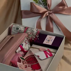 A closer look inside one of the Women's Day boxes. Each item is carefully chosen and arranged, from the floral scarf and makeup pouch to the custom-branded card and treats.
