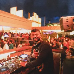 That happy moment when the beat drops and the whole crowd feels it. A great shot from a sundowner set at Pangeo, with the city lights in the background.