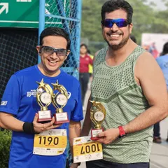 Two of our members holding trophies after a successful race. The pride and joy of winning is even sweeter when shared with your team.