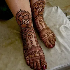 Elegant foot mehendi featuring the graceful Indian peacock. The intricate feathers and patterns cover the feet beautifully.