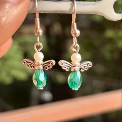 These adorable angel earrings are made with green crystal beads and pearls. A sweet and delicate design available in multiple colors.