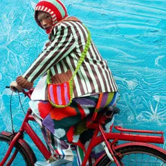 Capturing movement and vibrant energy for the "Kaleidoscope of Imagination" series. The contrast of the red bicycle against the blue wall adds to the playful, rebellious spirit of this high-fashion editorial.