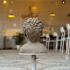 The back of a sculpted bust, showing the incredible texture and detail that goes into creating realistic hair from clay.