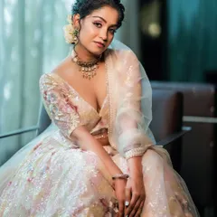 This image demonstrates our use of soft, natural light to create a dreamy and elegant atmosphere. The model, seated in a delicate floral lehenga, conveys a sense of quiet grace, highlighting the fine details of the embroidery and fabric.