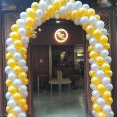 A bright yellow and white balloon arch creating a welcoming entrance for a local shop. This classic two-color spiral design is a popular choice for making a big impact.