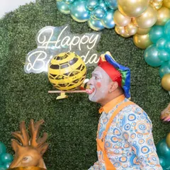 A talented clown entertains the children with his balancing act, bringing laughter and fun to the jungle-themed birthday celebration.