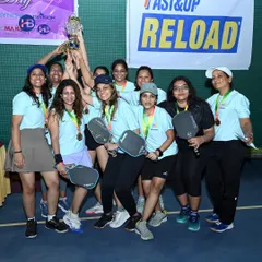 The victorious women's pickleball team lifts their championship trophy. We organize competitive and empowering tournaments for athletes of all ages and genders.