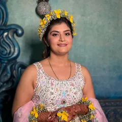 A portrait of the happy bride-to-be at her Haldi. The makeup is fresh and subtle, with a soft pink lip that complements the pastel tones in her lehenga.