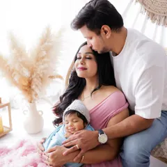 From a family of two to a family of three. This beautiful portrait captures the new parents adoring their newborn baby, a precious first family photo.