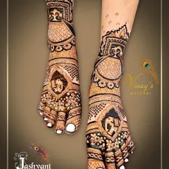A detailed bridal feet design featuring elephant motifs within intricate frames. The pattern covers the entire foot for a complete bridal look.