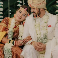 A quiet moment of togetherness on the wedding stage. The bride rests her head on the groom's shoulder, a simple gesture full of love and contentment.