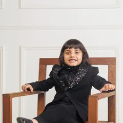 For a truly unique party look, I designed this tuxedo with a full sequin cowl neck detail. Here, the model is seated, showing how the outfit remains comfortable and stylish.