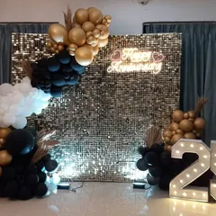 This is a direct view of the 25th-anniversary photo backdrop we designed. The light-up marquee numbers add a personalized touch, while the shimmering wall and balloon garland create a perfect spot for memorable photos.