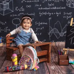 Welcome to class! This adorable little student is ready to learn, sitting at her desk in front of a chalkboard full of equations.