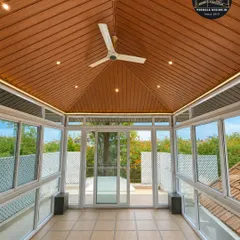 Step inside your personal, all-weather retreat. This view from within a completed glass room shows how we seamlessly blend the comfort of the indoors with the beauty of the outdoors, featuring a premium wood-finish ceiling, integrated fan, and panoramic views.