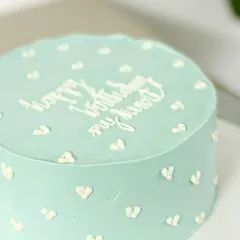 A minimalist and modern romantic cake. This light blue cake with tiny white hearts and the message "happy birthday my heart" is sweet and personal.