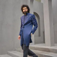 This is my modern take on the classic bandhgala. Crafted in a deep indigo, the asymmetrical cut and scattered embroidery on the shoulder and sleeve offer a contemporary edge, making it a perfect outfit for a Sangeet or reception.
