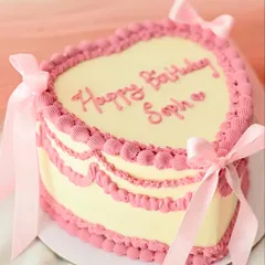 A classic vintage heart-shaped cake for a special birthday. This design features intricate pink Lambeth-style piping and delicate satin bows, bringing a touch of romantic nostalgia to the celebration.