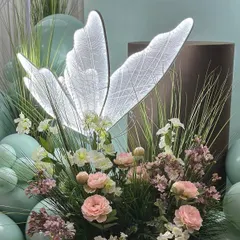 A close-up of the custom-made illuminated butterfly and the delicate pastel floral arrangement. These unique details are what make our themed decor stand out.