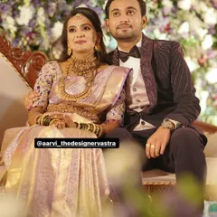 The couple at their reception. The bride's lavender saree and the groom's embroidered tuxedo were designed to match perfectly.