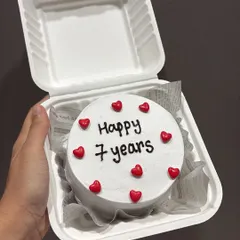 A simple and sweet bento cake to celebrate a 7-year anniversary. The minimalist design with red hearts is perfect for a romantic gesture.