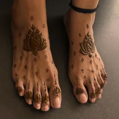 A simple and elegant lotus design for the feet. The central lotus is complemented by smaller buds on the toes, creating a clean and beautiful look.